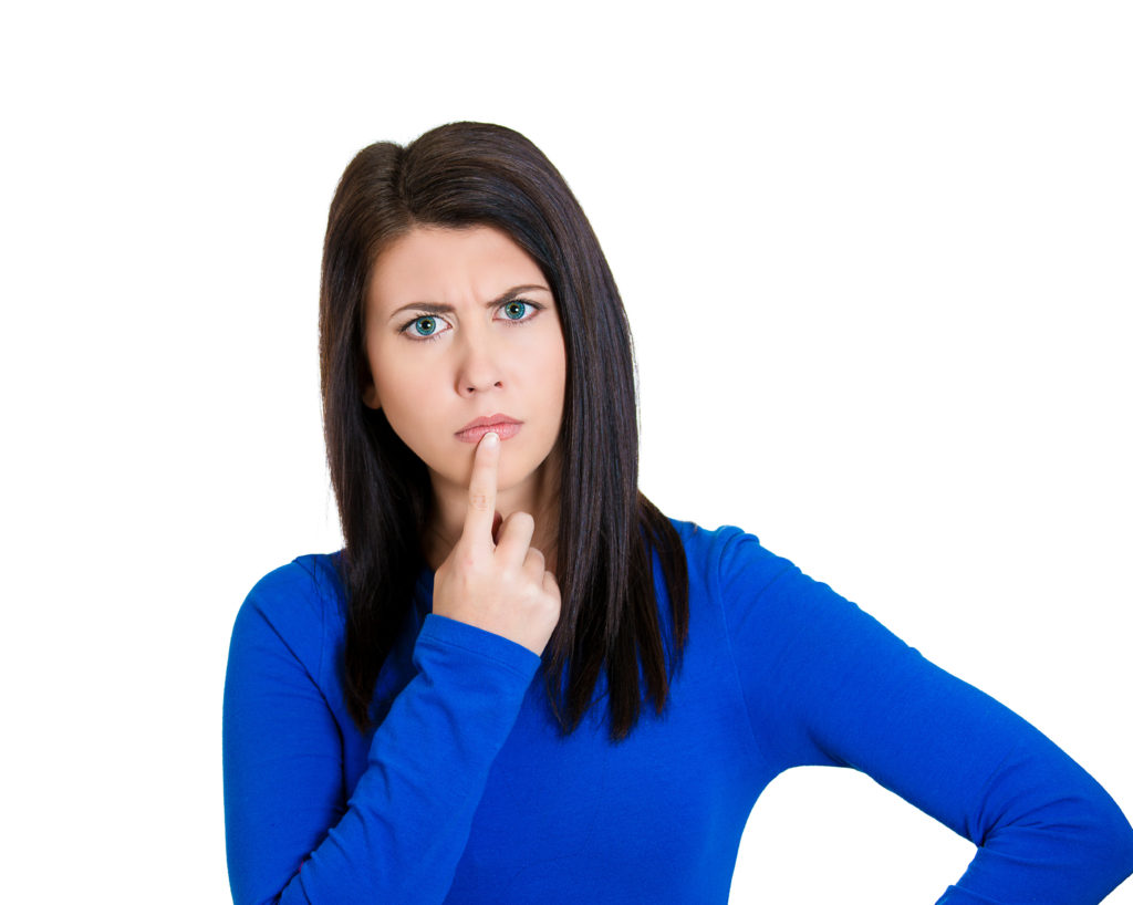 Young woman, finger on lips, looking confused surprised - Face Facts